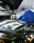 automobile oil is poured into the engine close up. pouring new oil into the engine. car engine oil change