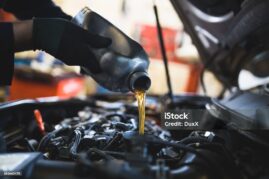 Close up hands of unrecognizable mechanic doing car service and maintenance.